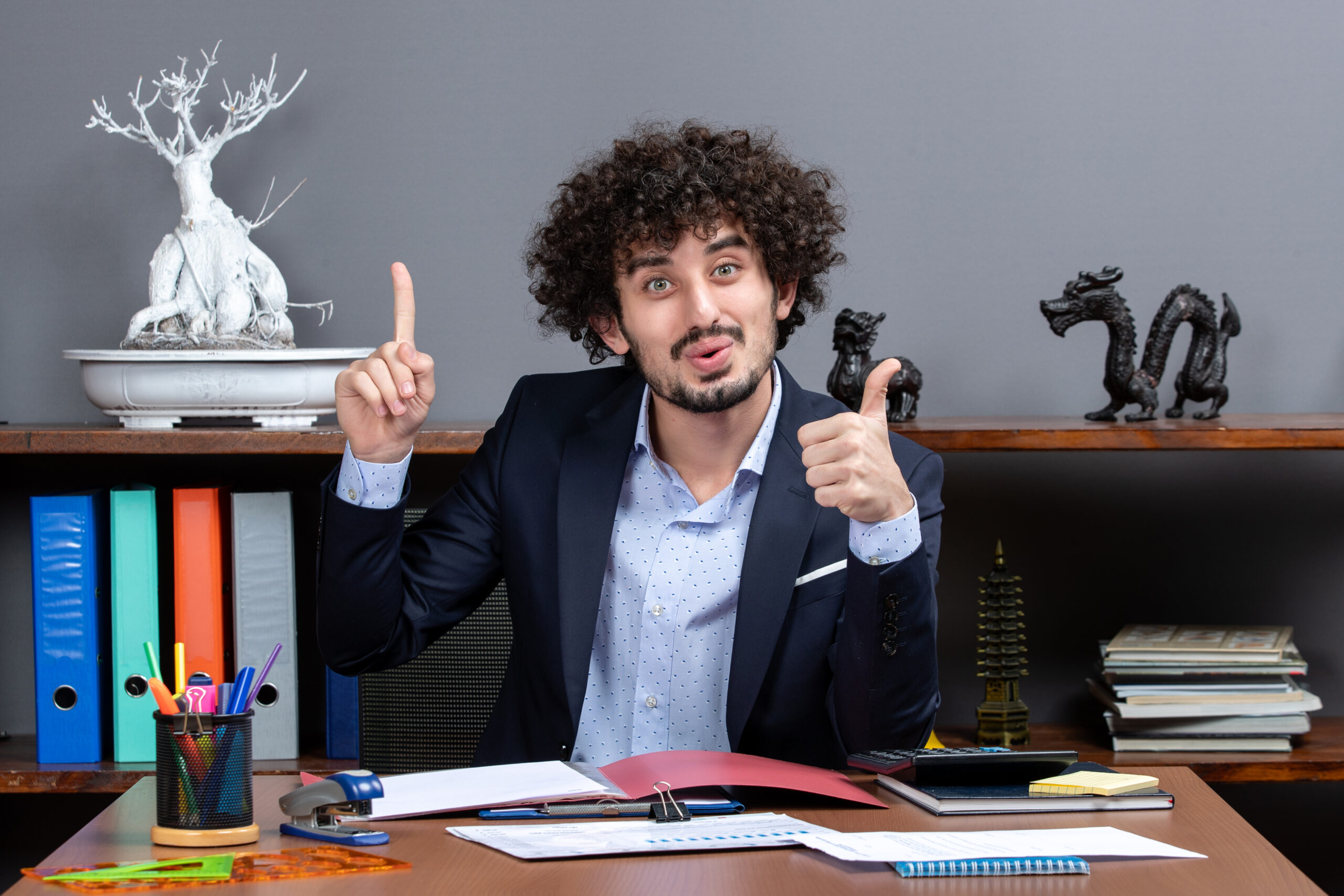 front view cool office worker giving thumbs up sitting desk office scaled