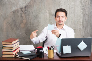 office employee showing his memo pad office desk scaled